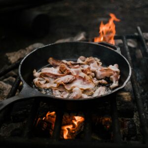 Cast iron pan cooking over an open campfire