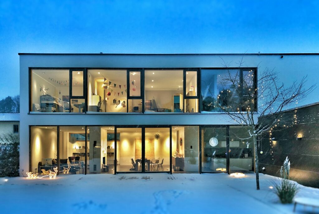 Modern two-storey family home lit from within at dusk