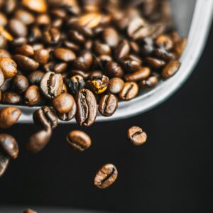 Roasted espresso beans falling from a scoop